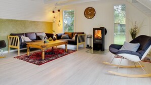 A modern living room with a wooden coffee table, two sofas, a rocking chair, and a wood-burning stove. - "Ingalil" - 650m from the sea by Interhome (Væggerløse)