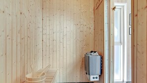 Un sauna avec des murs en bois, un banc et un appareil de chauffage pour sauna.