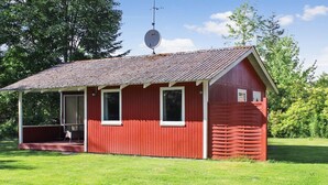 En liten, röd träbyggnad med ett sluttande tak och en satellantenn.