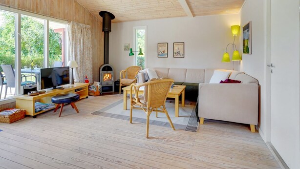A cozy living room with a fireplace, wooden furniture, and large windows. - "Mile" - 260m from the sea by Interhome (Idestrup)