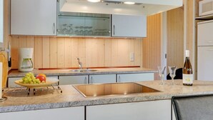 Eine moderne Küche mit einer Granit-Arbeitsplatte, einem Edelstahlspülbecken und weißen Schränken.