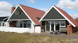 A two-story house with a red roof and white trim.