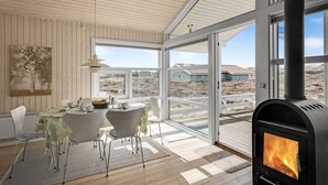 A modern interior with a large window, a fireplace, and a dining area. - "Ferdine" - 1.5km from the sea by Interhome (Fanø)