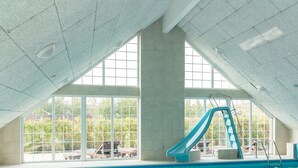 En inomhuspool med en vattenrutschkana, stora fönster och utsikt över omgivningarna.