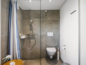 A modern bathroom with a shower, toilet, and a small sink. - "Ute" - 200m from the sea by Interhome (Fanø)