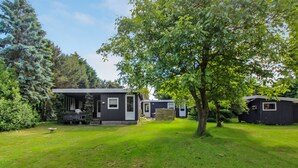 A residential area with multiple mobile homes, a grassy lawn, and surrounding trees. - "Frode" - 400m from the sea by Interhome (Idestrup)