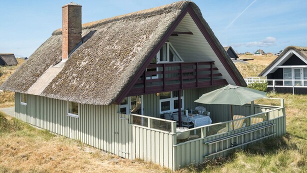 A thatched-roof house with a balcony, a chimney, and a view of the surrounding landscape. - "Inra" - 400m from the sea by Interhome (Fanø)