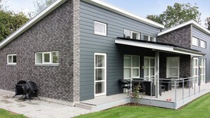 A modern two-story house with a grey brick exterior, large windows, and a covered patio area. - "Bjerne" - 200m from the sea by Interhome (Rødvig Stevns)