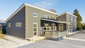 A modern building with a flat roof, large windows, and a covered entrance area. - "Bjerne" - 200m from the sea by Interhome (Rødvig Stevns)