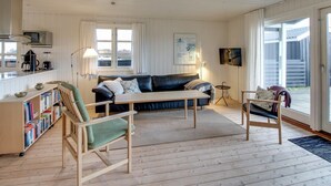 A cozy living room with a black leather sofa, wooden coffee table, and a bookshelf. - "Eikka" - 600m from the sea by Interhome (Fanø)