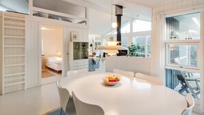 A modern kitchen with a central island, white cabinetry, and a large window providing natural light. - "Fenneke" - 50m from the sea by Interhome (Blokhus)