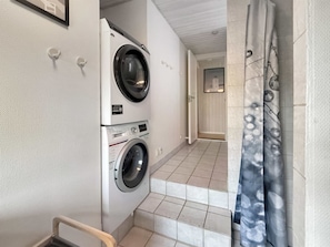 A laundry room with two washing machines, a tiled floor, and a shower curtain. - "Steffenie" - 400m from the sea by Interhome (Løkken)
