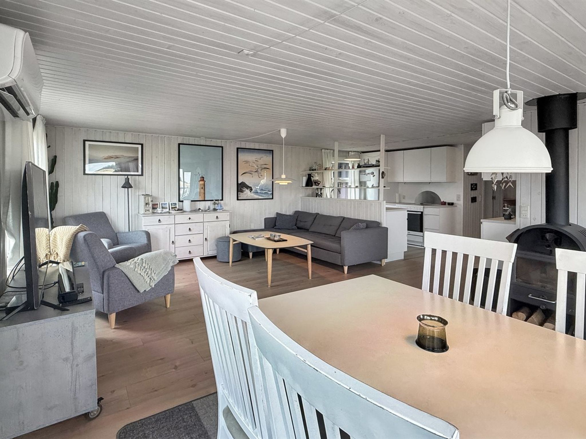 Een moderne woonruimte met een eethoek, bank en keuken.