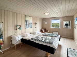 A bedroom with a bed, bedside tables, a window, and a wall-mounted lamp. - "Steffenie" - 400m from the sea by Interhome (Løkken)