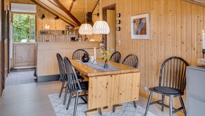 A wooden interior with a dining area, kitchen, and a view of the outdoors. - "Ija" - 200m from the sea by Interhome (Føllenslev)