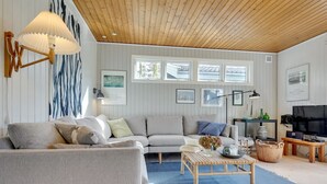 A modern living room with a grey sofa, a wooden coffee table, and a television on a wooden stand. - "Gærmund" - 350m from the sea by Interhome (Føllenslev)
