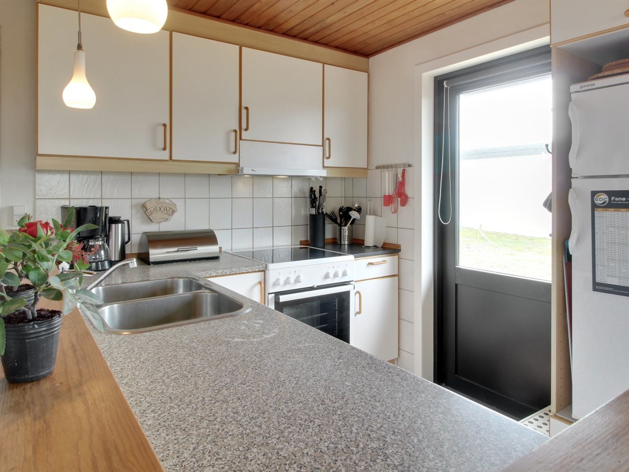 A modern kitchen with granite countertops, stainless steel appliances, and white cabinetry.