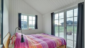 Une chambre avec un grand lit, une fenêtre et une vue sur l’extérieur.
