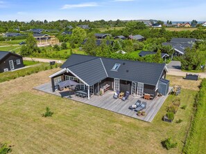 A large house with a spacious deck, a covered patio, and a view of a residential area.