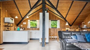 Un interior de cabaña acogedor con cocina, comedor y sala de estar.