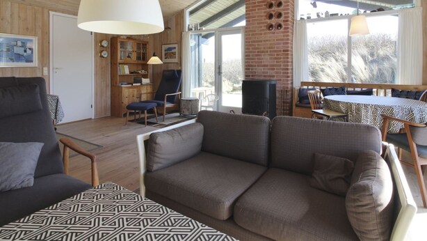 Un salon confortable avec un canapé, des fauteuils et un coin repas comprenant une table et des chaises.