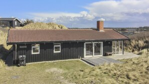 Un bâtiment moderne doté d’un toit plat, de grandes fenêtres et d’une cheminée.