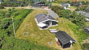 A residential area with houses, a grassy yard, and a view of the sea.