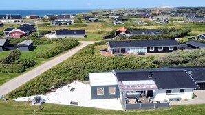Un quartier résidentiel avec des maisons, un sentier et un grand bâtiment blanc doté d’une terrasse.
