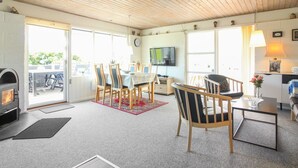 Un salon confortable avec une cheminée, un coin repas et un téléviseur.