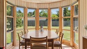 A round table with six chairs in a room with large windows and wooden walls. - "Linda" - 600m from the sea by Interhome (Sjællands Odde)