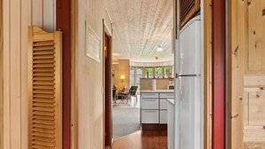 A wooden interior hallway with a kitchen area visible in the background, featuring a dining table and chairs. - "Linda" - 600m from the sea by Interhome (Sjællands Odde)
