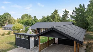 Une maison moderne dotée d’un grand garage et d’un espace extérieur abrité.