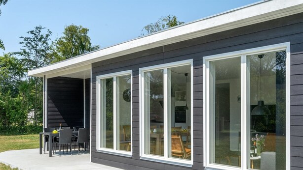 A modern house with large windows and a covered patio area.