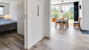 A modern, open-plan living space with a dining area and a bedroom.