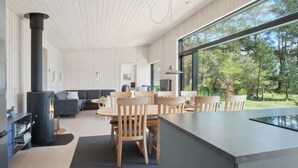 A modern interior with a large window, a fireplace, a dining area, and a living room. - "Toska" - 100m to the fjord by Interhome (Rørvig)