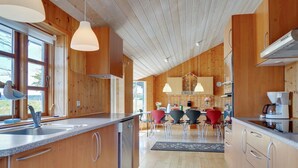 A modern kitchen with wooden cabinetry, a central island, and pendant lighting.