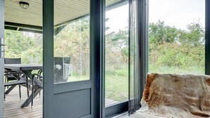 Un intérieur moderne avec une porte vitrée donnant sur un espace extérieur.