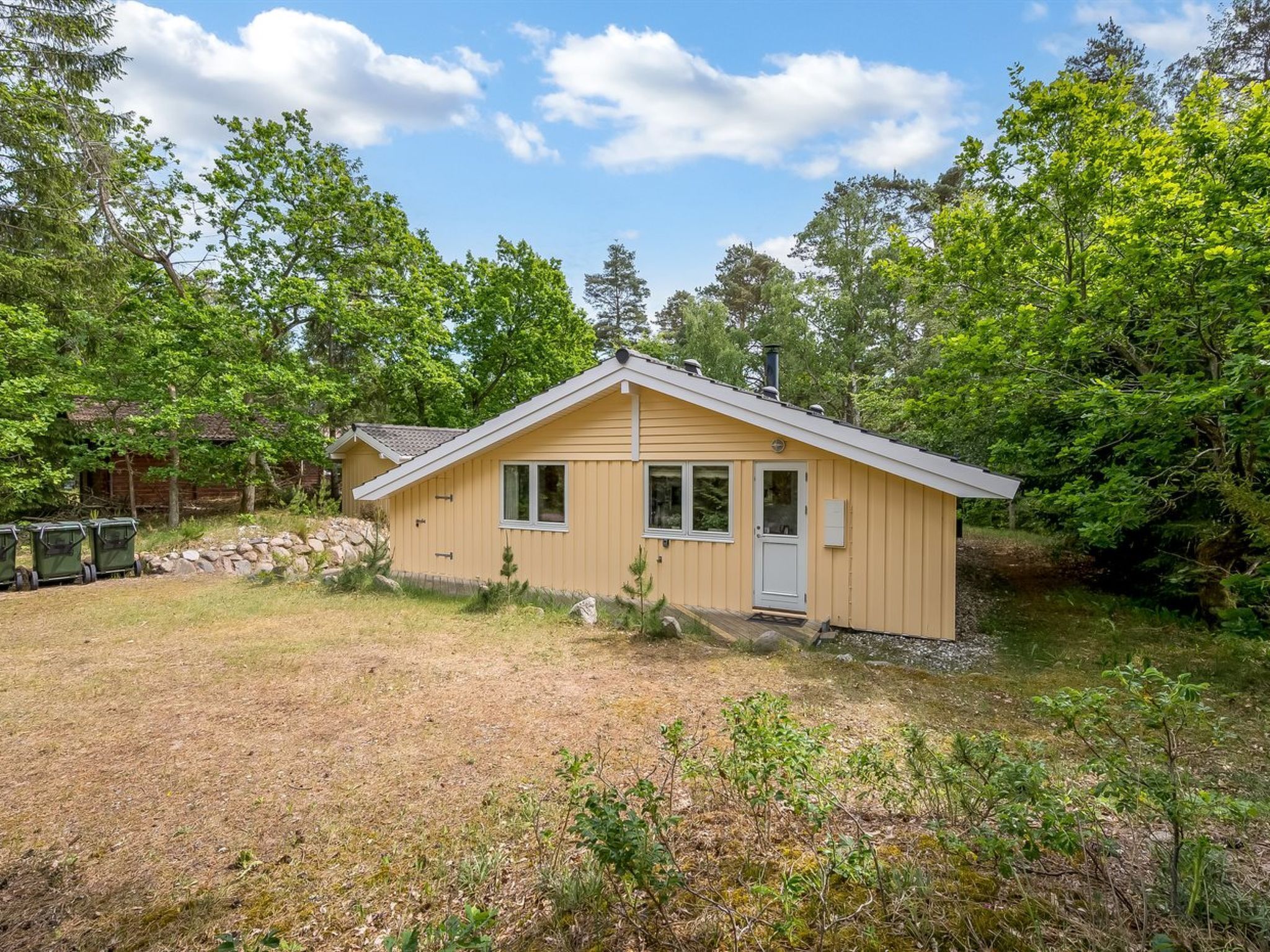 A small, single-story cabin with a gabled roof, a front door, and a small porch area.