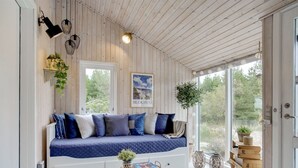 A cozy room with a blue and white sofa, a patterned rug, and a small round table with a plant. - "Elayne" - 3km from the sea by Interhome (Blokhus)
