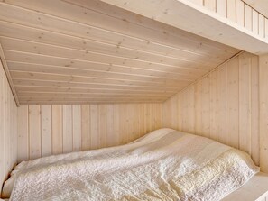 Una habitación con techo inclinado y paredes de madera.