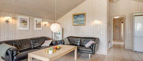 A modern living room with a sofa, coffee table, and artwork on the walls.