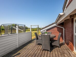 A wooden deck with outdoor furniture and a covered area. - "Claudius" - 1.3km to the fjord by Interhome (Tarm)