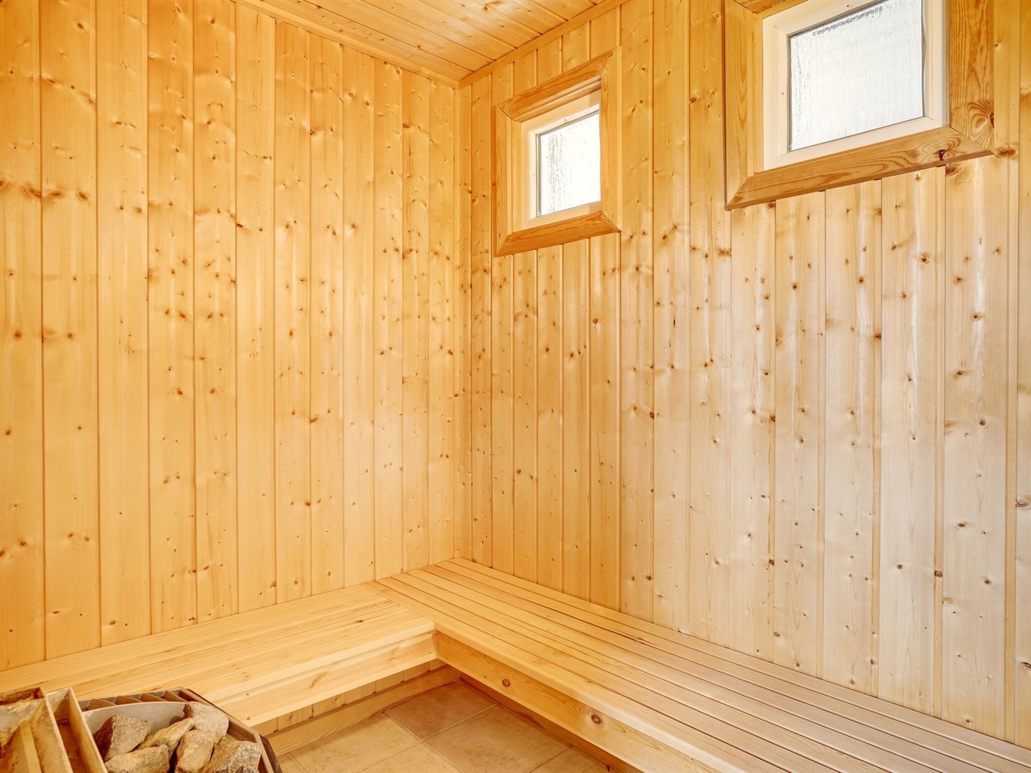 Una sauna in legno con panche e una finestra.