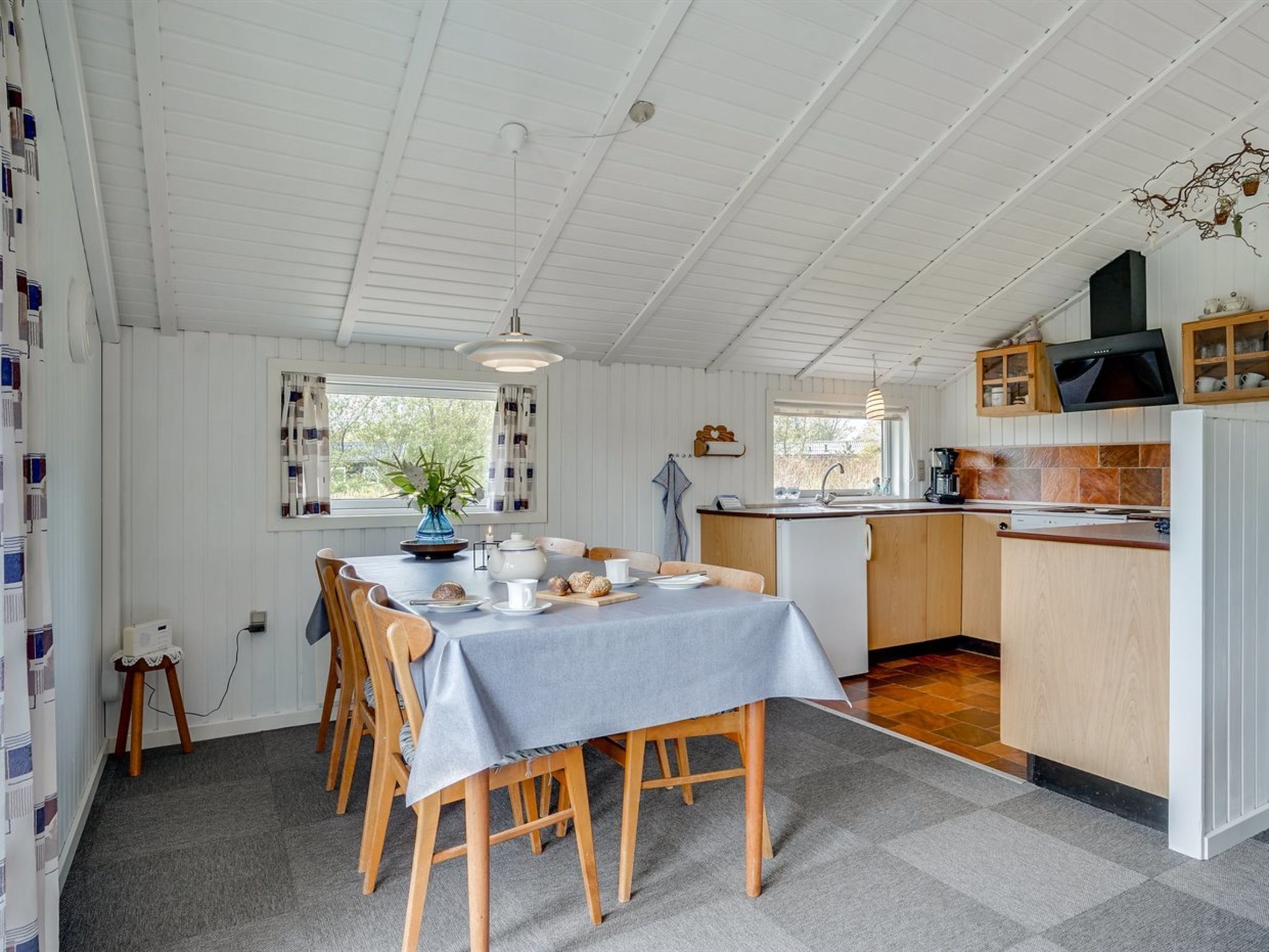 Une cuisine compacte avec des meubles en bois, un four encastré et un petit îlot central doté d’un évier.