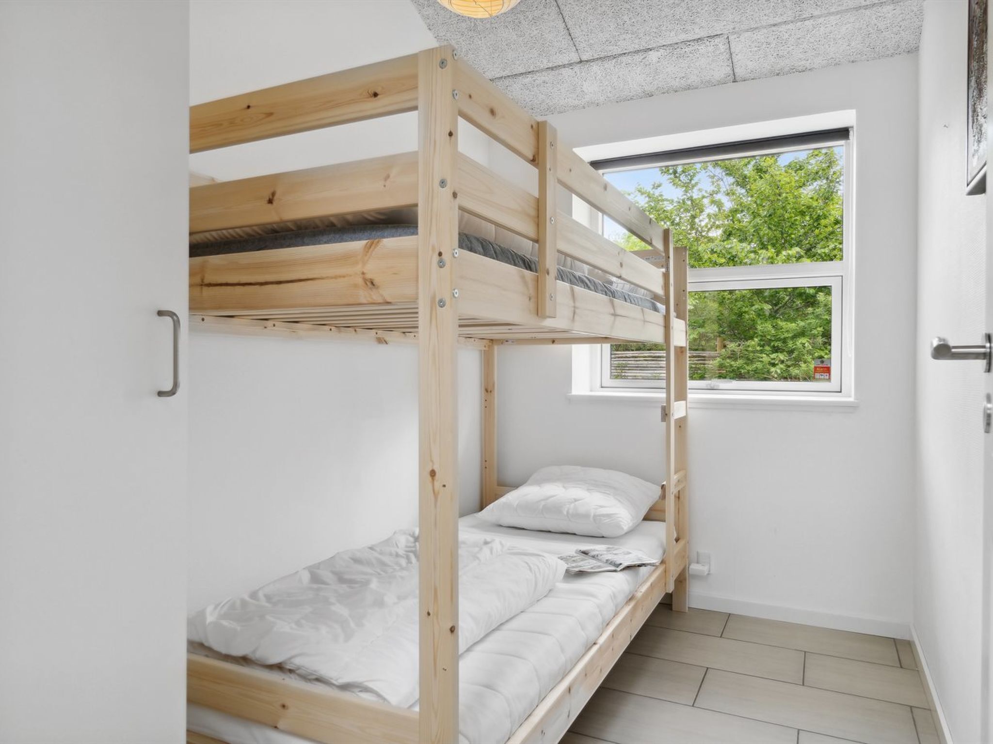 Habitación con literas y ventana que ofrece vistas a zonas verdes.