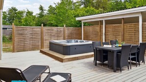 A covered outdoor patio with a hot tub, dining table, and lounge chairs. - "Barth" - 950m from the sea by Interhome (Vig)