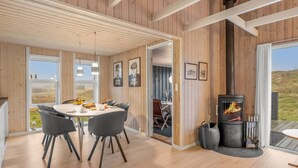 Un interior moderno con comedor, paredes de madera y chimenea.