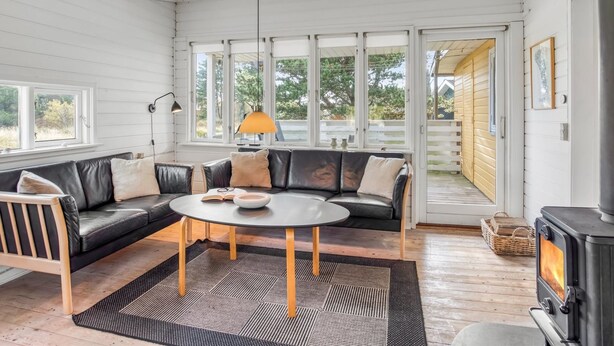 A cozy living room with a leather sofa, a round coffee table, and a wood-burning stove. - "Heinke" - 2km from the sea by Interhome (Fanø)