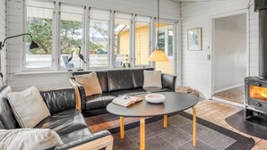 A modern living room with a black leather sofa, a round coffee table, and a wood-burning stove. - "Heinke" - 2km from the sea by Interhome (Fanø)