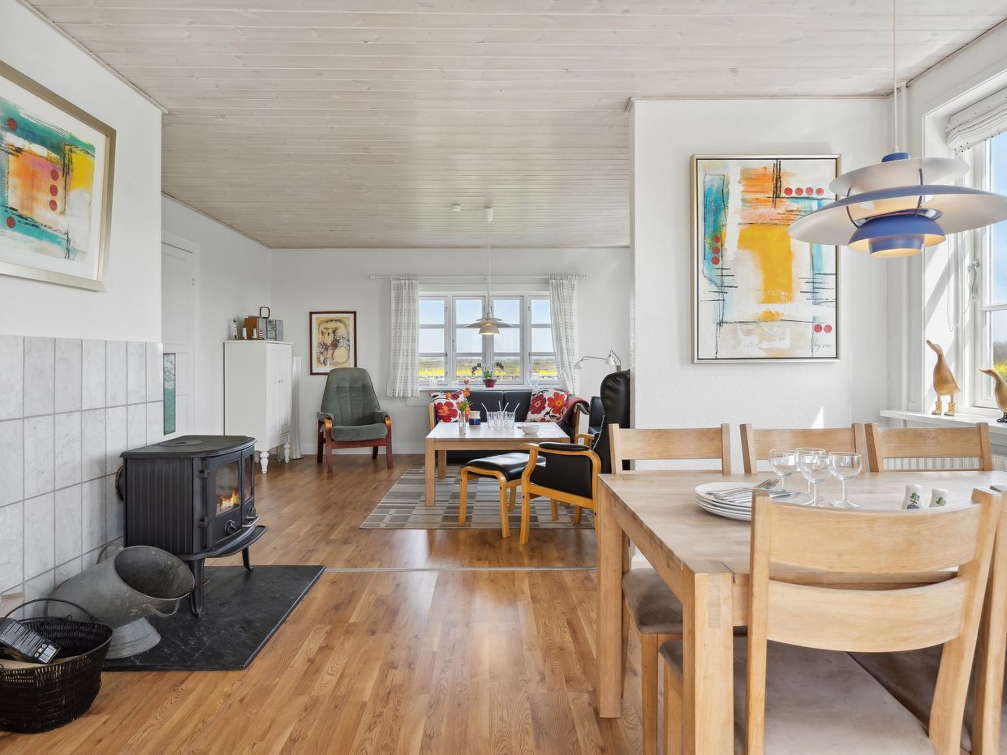 A spacious dining area with a wooden table, chairs, and a view through the window.